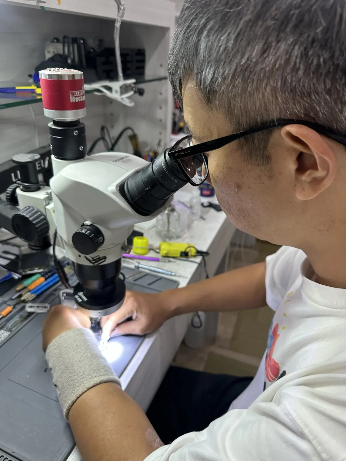 技師使用顯微鏡進行主機板維修